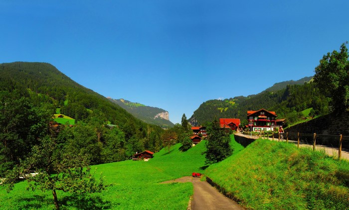 Houses in Lauterbrunnen, Switzerland with Mountains and Green Scenery