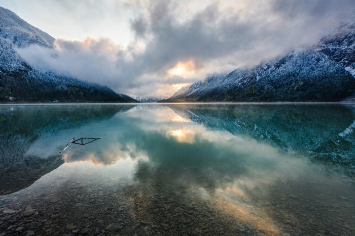 Lake with snow-capped mountains and reflection in Tirol, Austria
