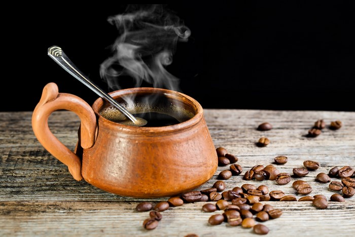 Hot Coffee in a Clay Cup with Coffee Beans