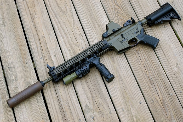 STAG-15 rifle with accessories on wooden deck