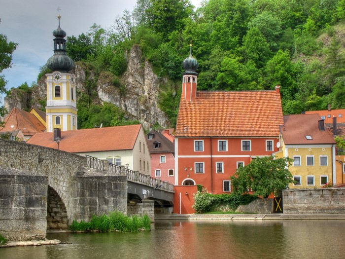 River and historic buildings with church tower and bridge in Germany