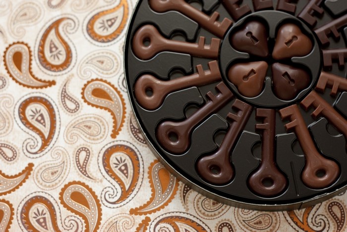 Chocolate key candies in a box on a paisley background