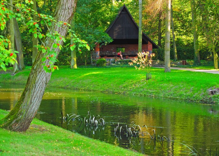 Park with a river and a brick building in Sochaczew, Poland