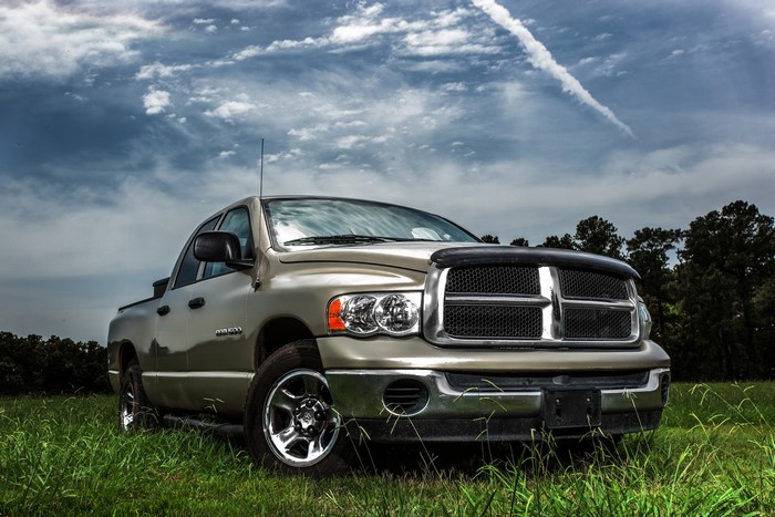Dodge Ram 1500 truck in a grassy field under a cloudy sky