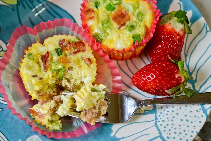 Egg bites with bacon and strawberries on a plate