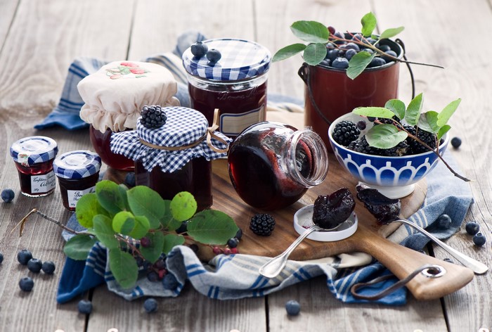 Jars of Blackberry and Blueberry Jam with Fresh Berries
