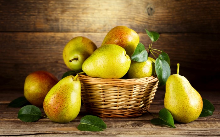 Pears in a wicker basket on a wooden table