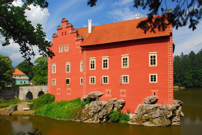 Red castle on a pond in the Czech Republic
