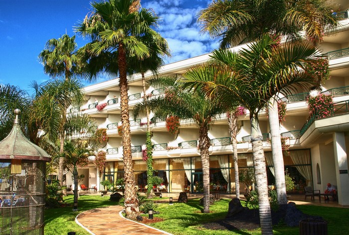 Hotel with palm trees and garden in Playa Blanca, Canary Islands
