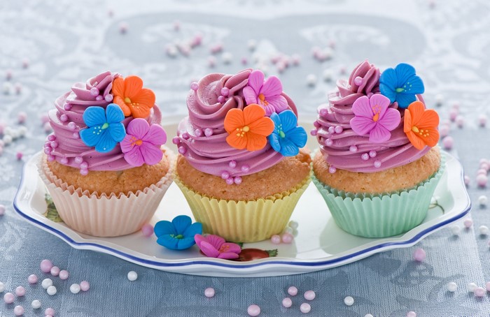 Three decorated cupcakes on a plate
