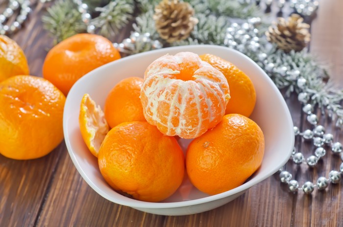 Mandarin oranges in a bowl with Christmas decorations