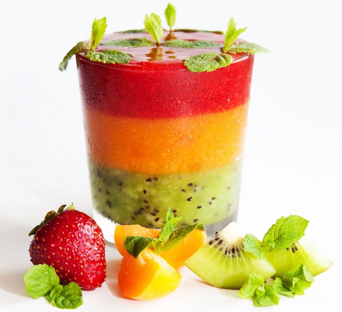 Layered fruit smoothie with strawberry, apricot, and kiwi