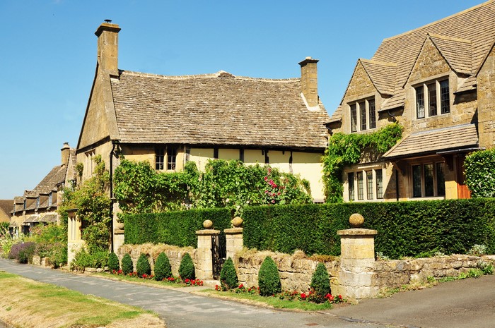 Cotswold stone houses with hedges and fences in Broadway, England