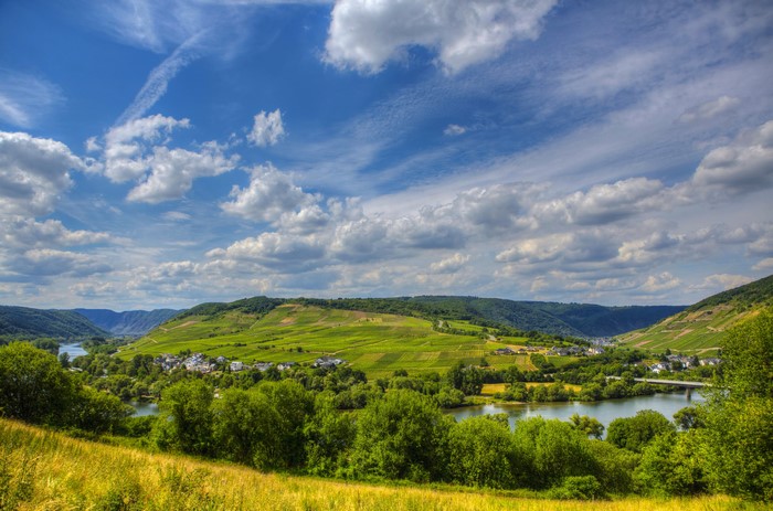 River valley with vineyards and village under a cloudy sky