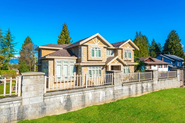 Luxury stone house with fence and trees