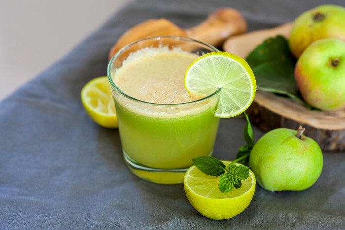 Glass of green juice with apples and limes