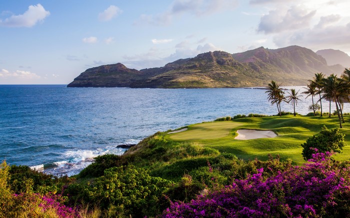 Golf course by the sea with mountains