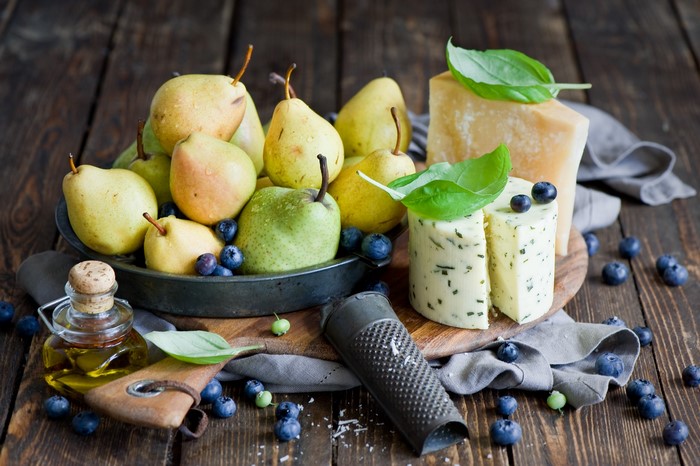 Still life of pears, cheese, blueberries, and olive oil