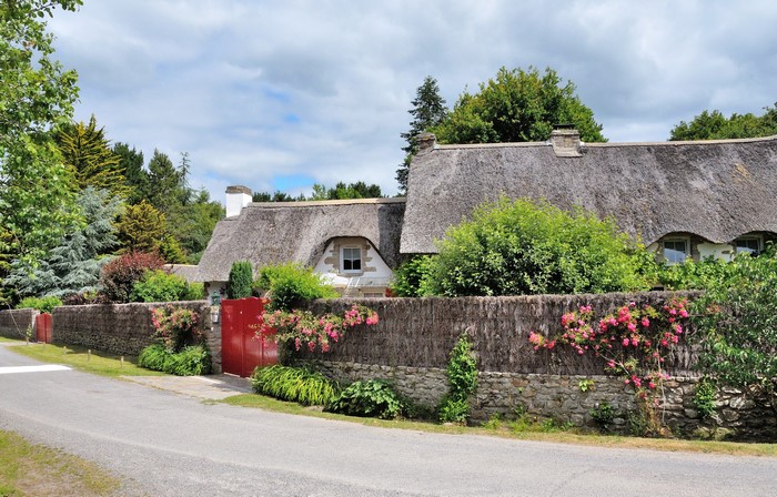Thatched roof houses with red gates in Saint-Lyphard, France