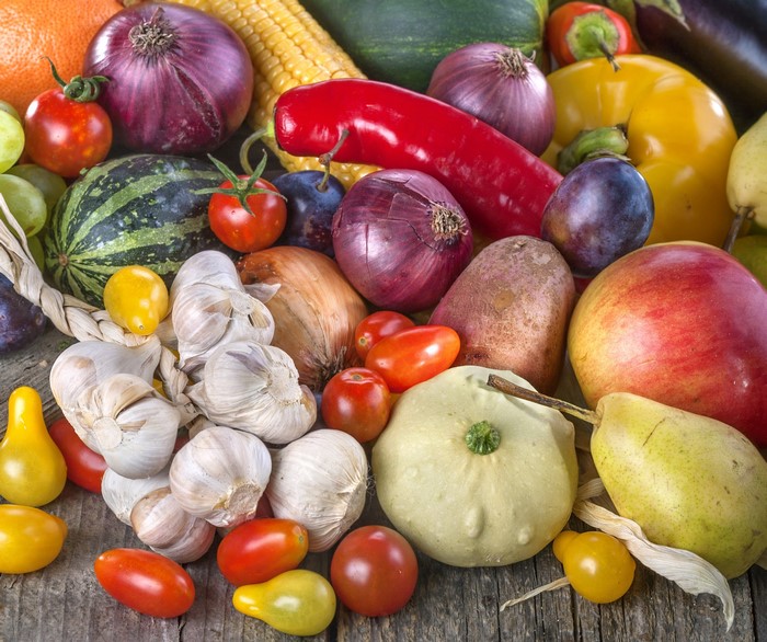 Assortment of fresh fruits and vegetables on a wooden surface