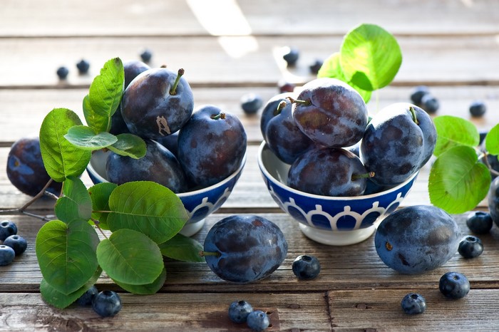 Plums and blueberries on wooden table