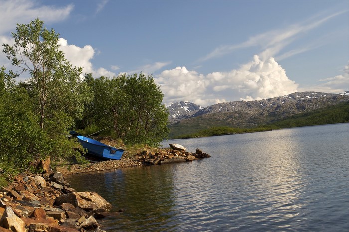 Blue boat on the shore of a lake in Norway