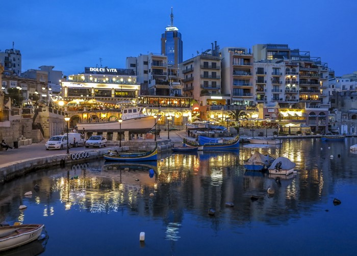 St. Julians, Malta waterfront at night with boats and buildings