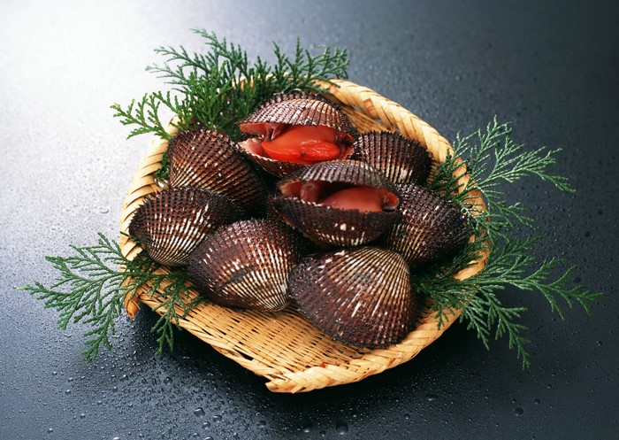 Cockles in a wicker basket with greenery