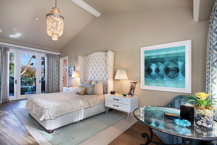 Bedroom with tufted bed and modern art