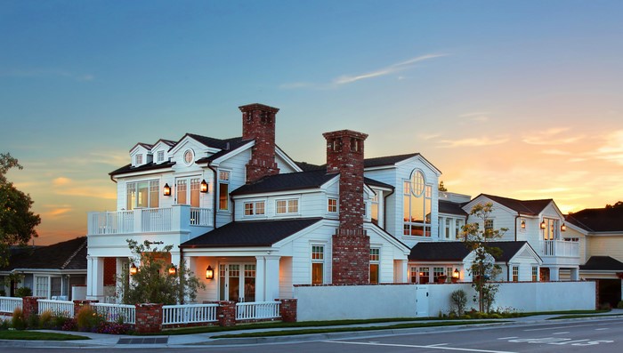 White modern house with brick chimneys at sunset