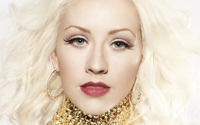 Christina Aguilera with blonde hair and gold necklace