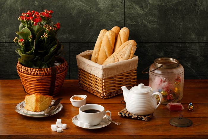 Still-life with bread, cake, coffee, and flowers