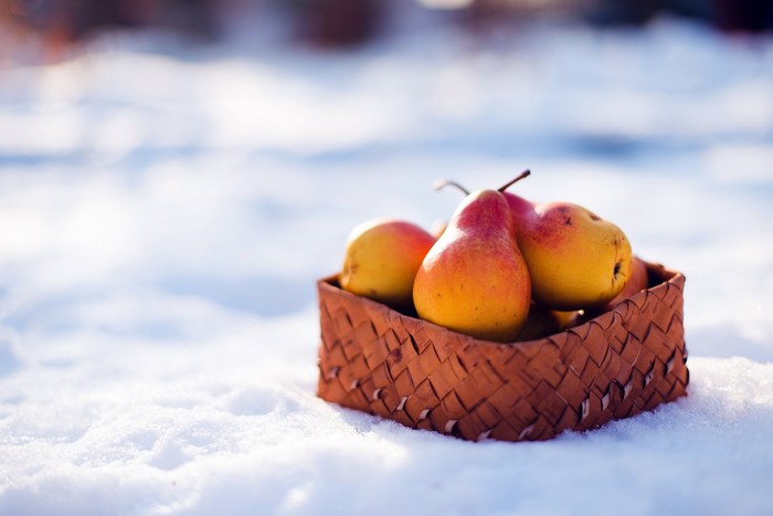 Pears in a wicker basket on snow