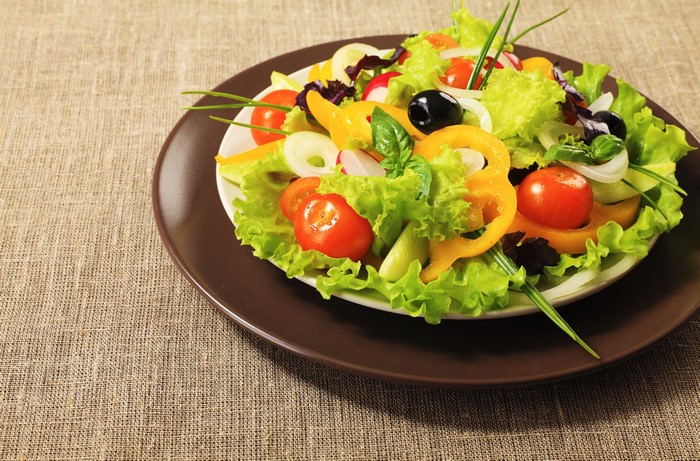 Fresh salad on a brown plate