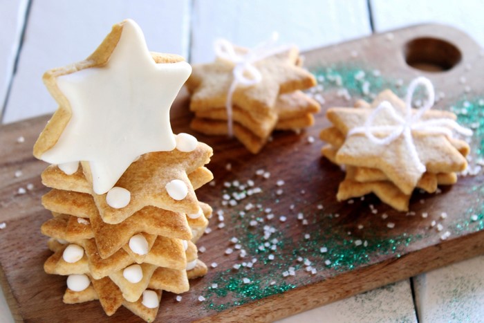 Star-shaped Christmas cookies stacked on a wooden board