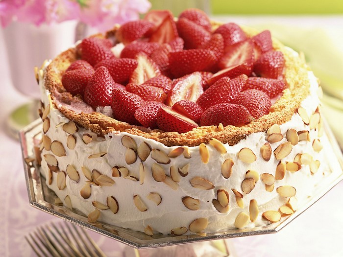 Strawberry cake with whipped cream and almonds