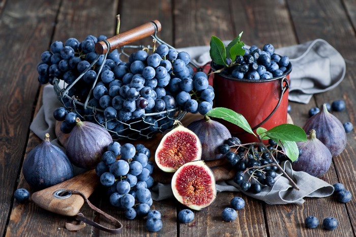 Grapes, Figs, Blueberries, and Aronia berries on a wooden table