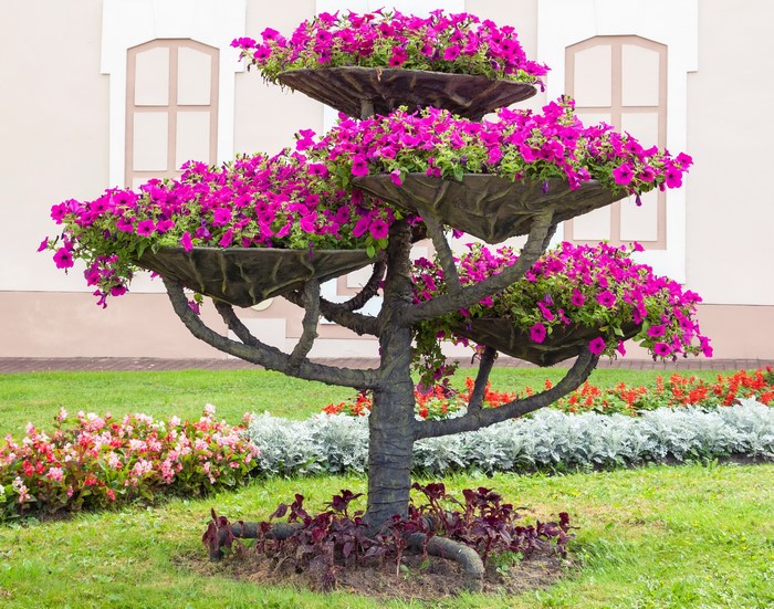 Tiered planter with pink petunias in a garden
