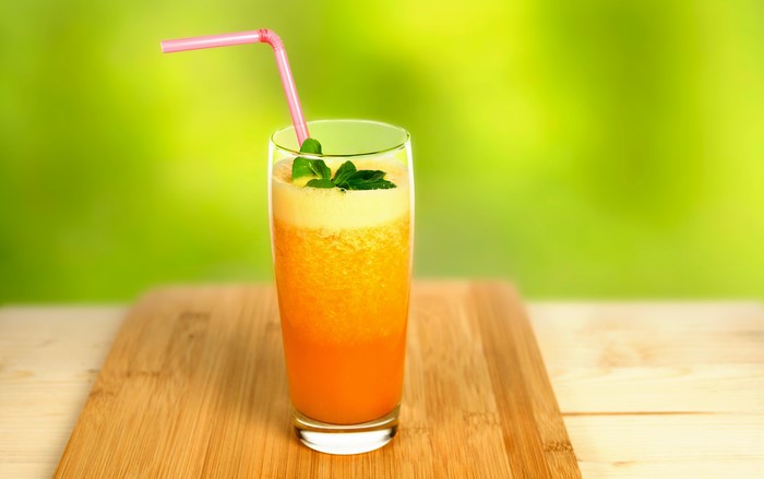 Orange juice in a highball glass with a straw