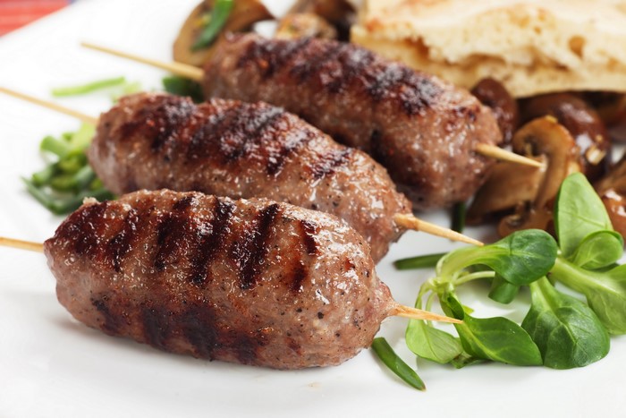 Grilled meat skewers with mushrooms and salad