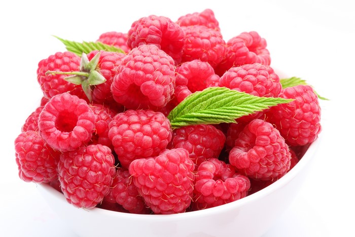 Bowl of Raspberries with Green Leaves