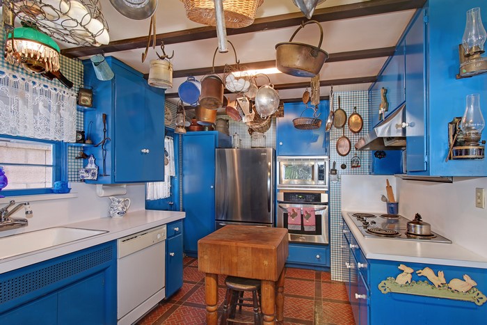 Blue country kitchen with hanging pots and pans