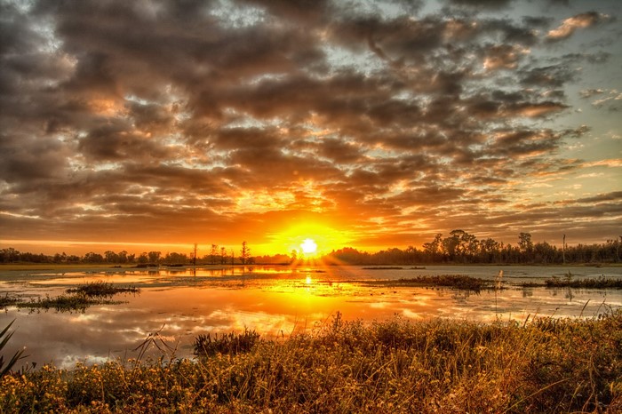 Sunset over a marsh with dramatic clouds