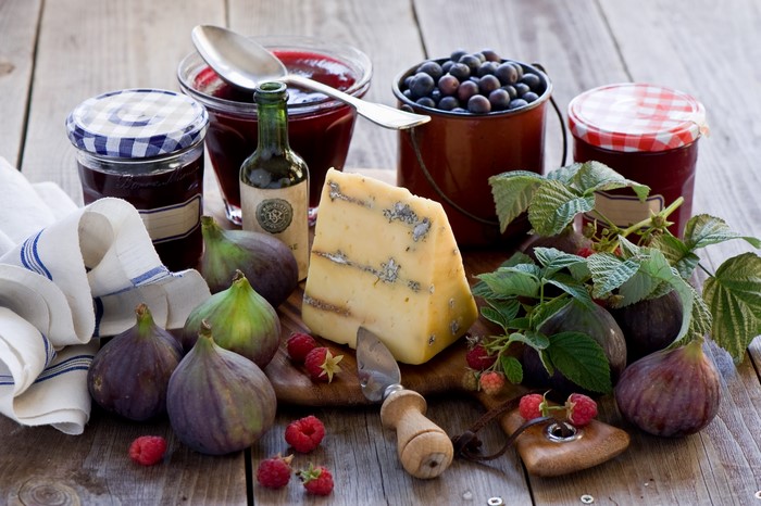 Still-life with cheese, jam, figs, blueberries, and raspberries