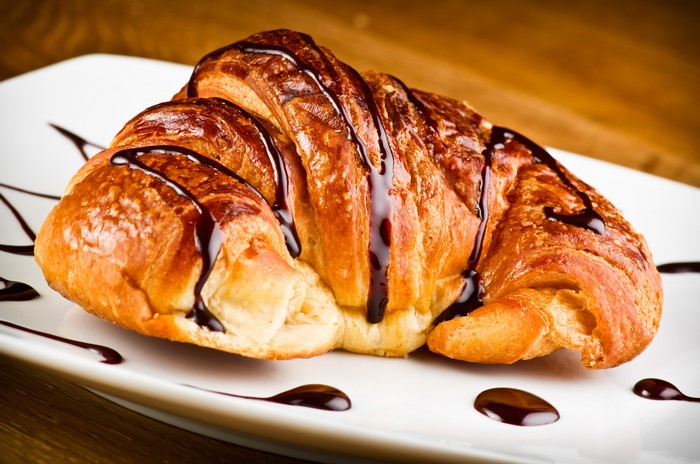 Chocolate Drizzled Croissant on a White Plate