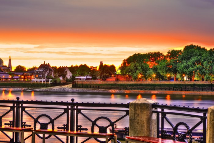 Riverfront buildings and trees at sunset in London