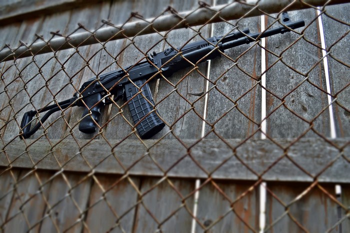 Saiga shotgun resting on a wooden fence