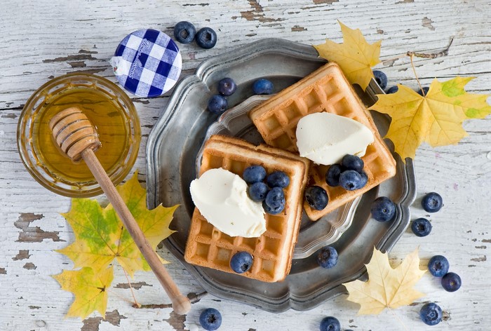 Waffles with blueberries and cream on a platter