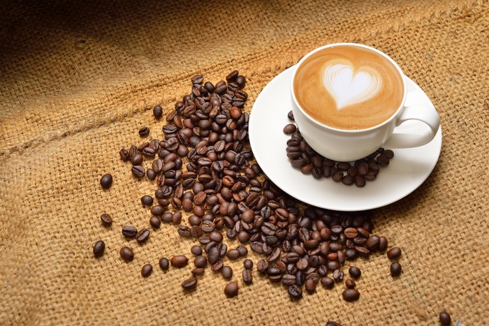 Latte art coffee cup with coffee beans