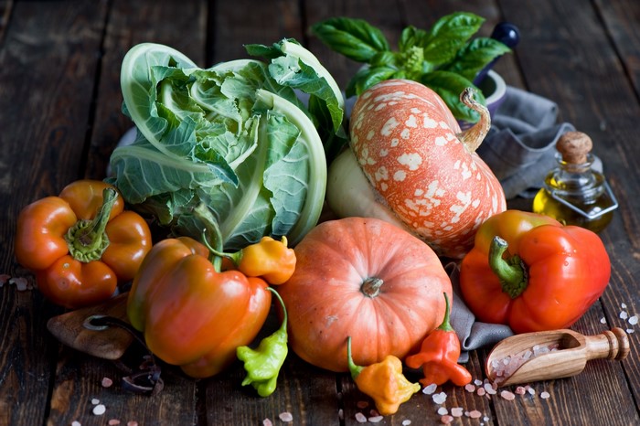 Assortment of fresh vegetables including pumpkins, bell peppers, and cabbage